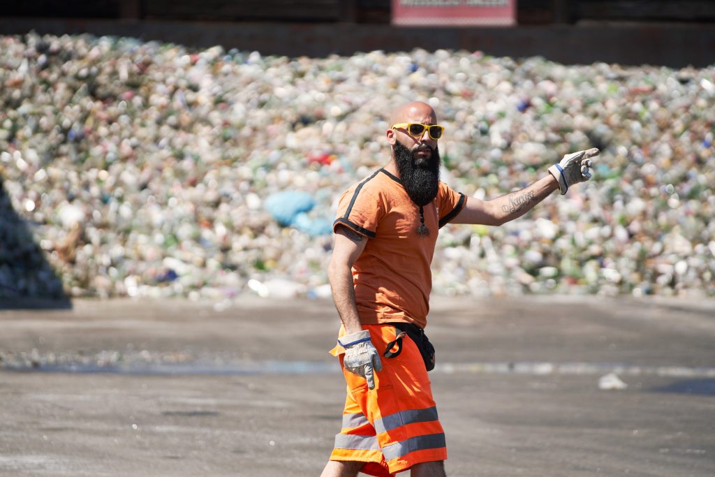 Mitarbeiter von Berlin Recycling in T-Shirt winkt freundlich durch